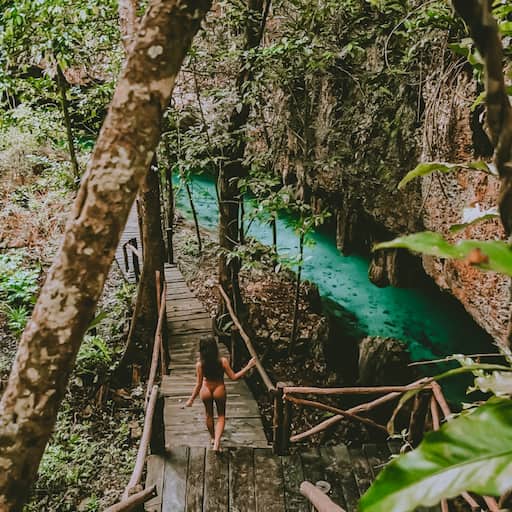 woman walking down wooden steps to turquoise water 2026 03 13 01 54 42 utc 2 1